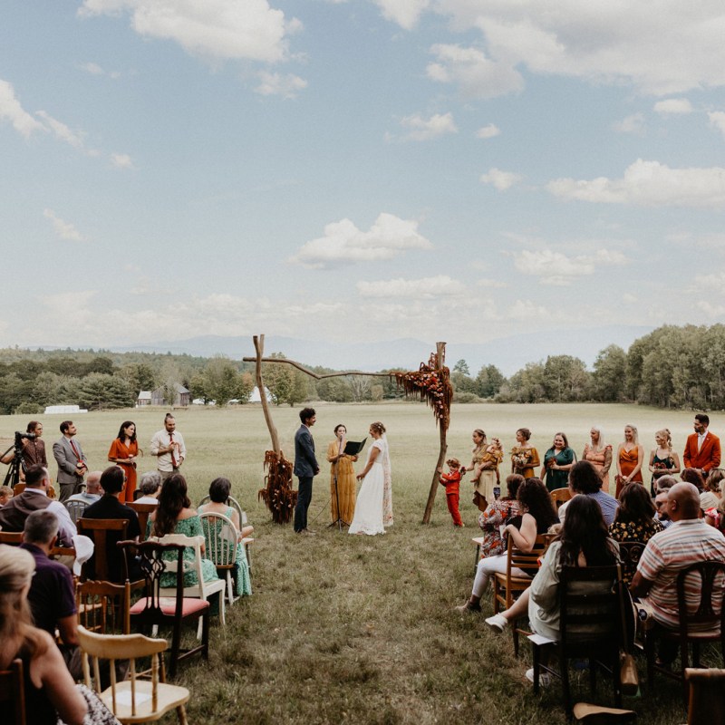 A couple getting married in front of mountains at Wild Sugar Homestead in Newbury, Vermont